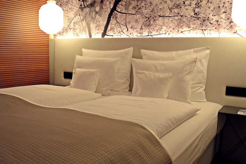 Bett mit vielen Kissen im me and all hotel düsseldorf
